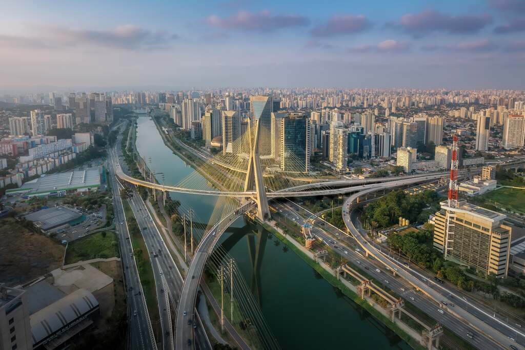 Vista panorâmica da cidade de São Paulo com prédios e céu colorido ao entardecer